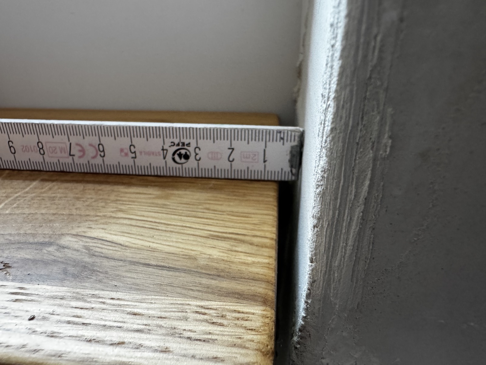 Fensterbrett im Treppenhaus: rund 6–7 mm Fuge zur Wand, gemessen mit dem Zollstock.