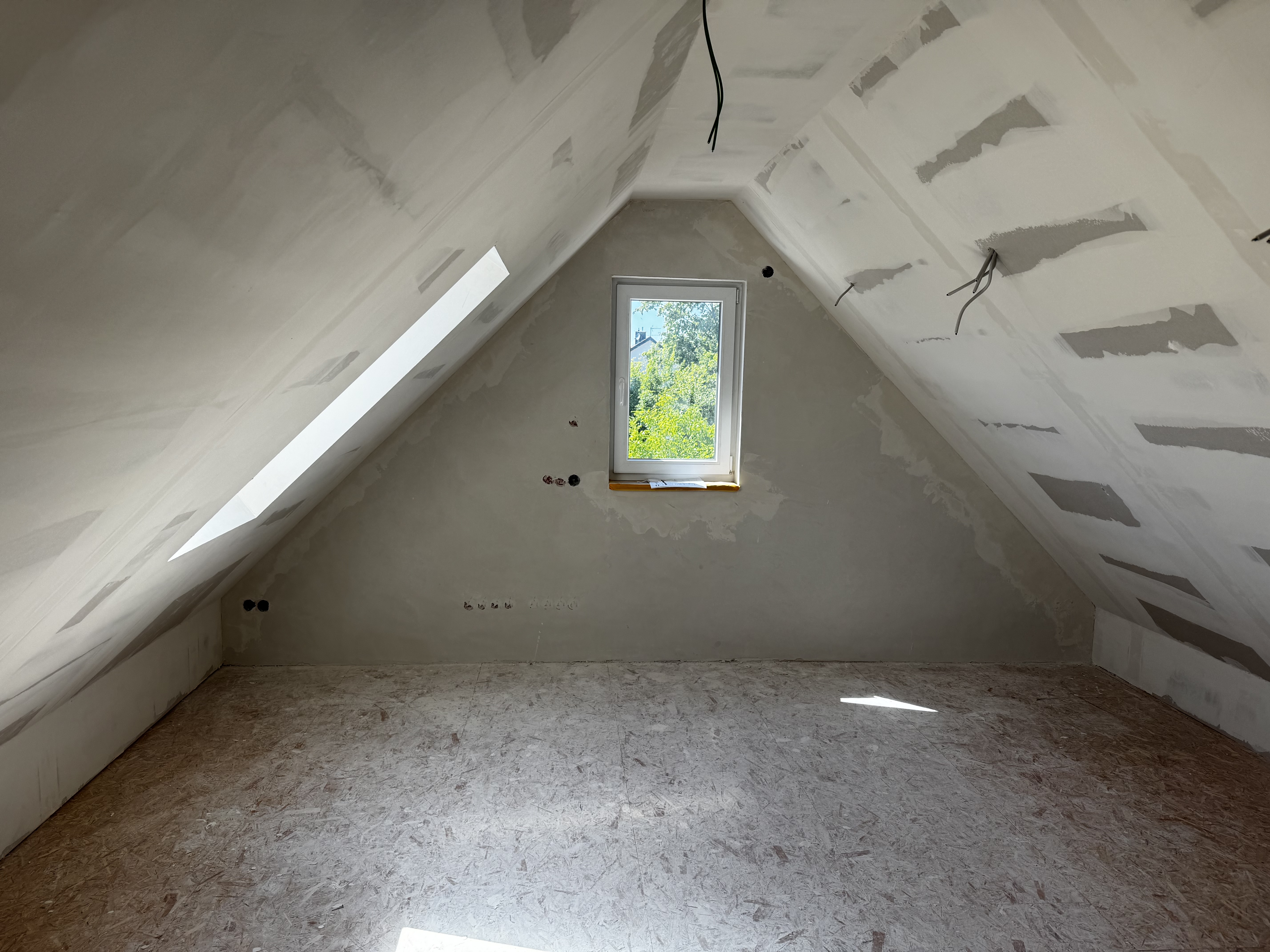Der Dachspitz mit verkleideter Decke — die Deckenfläche über dem First ist schräg.