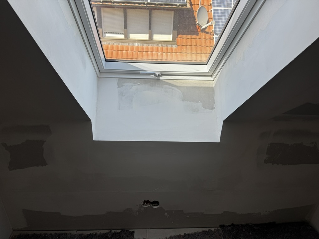 Dachfenster im Dachspitz: Die Laibung hängt rechts sichtbar Richtung Boden.